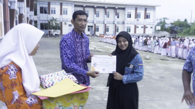 
 Caption: Kepala SMA Negeri 16 Samarinda Abdul Razak saat memberi sertifikat penghargaan peserta MPLS Terbaik 2023